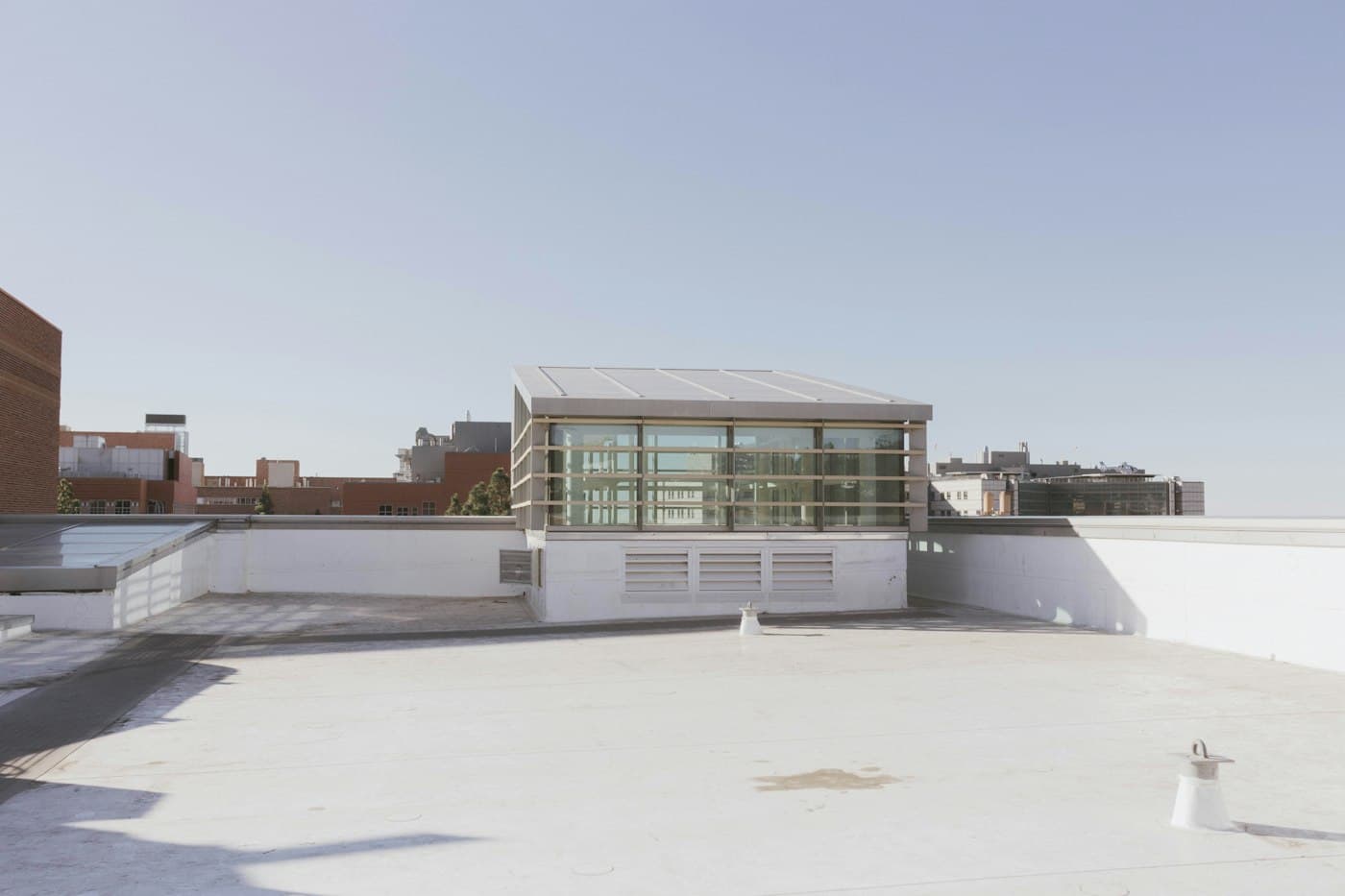 A low-slope commercial roof with a light-colored membrane and a rooftop structure
